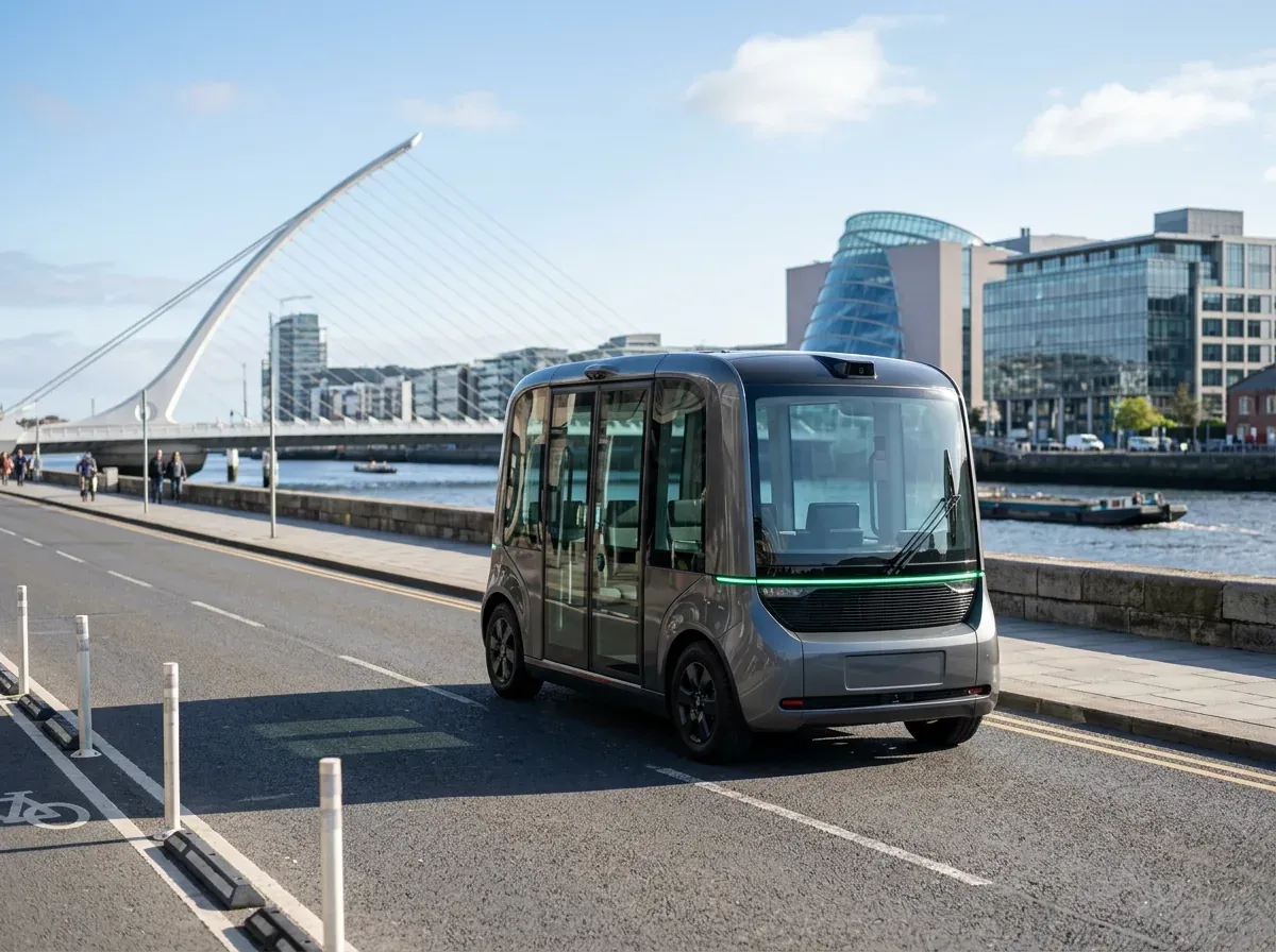 An autonomous shuttle with a green light strip on a Dublin riverside street